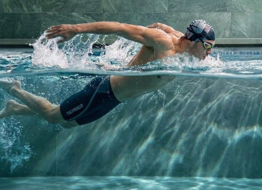 A swimmer filmed side-on through the waterline. Llyr has drawn his joints and the bones between them across the half of his body above the water. Below the surface the frame is hatched and empty, because the tracker could not see his submerged arm and legs.